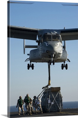 Marines Attach The Hoist Sling Of An AV-8B Harrier Jet Engine Container To MV-22 Osprey