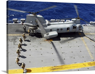Marines Board A CH-46E Sea Knight Helicopter On The Flight Deck Of USS Peleliu