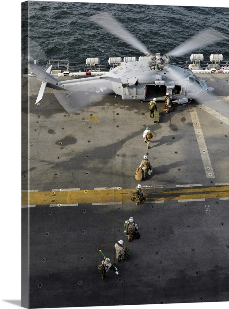 Marines prepare to board an MH-60S Sea Hawk helicopter aboard USS Peleliu.