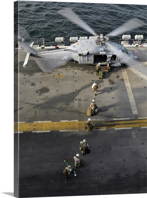 Marines prepare to board an MH-60S Sea Hawk helicopter aboard USS Peleliu