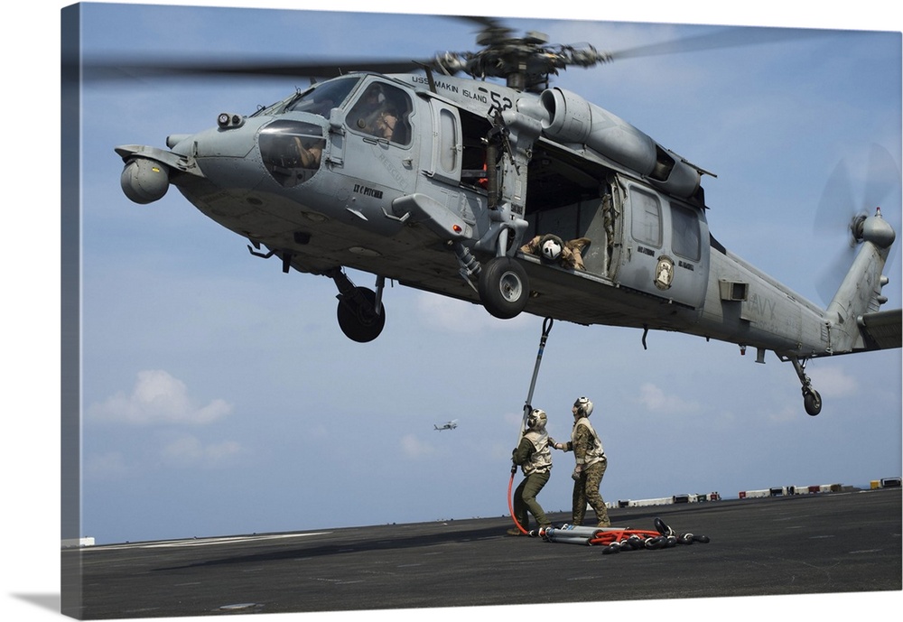 Gulf of Aden, December 9, 2014 - Marines secure a hoist sling to an MH-60S Seahawk helicopter on the flight deck of the am...