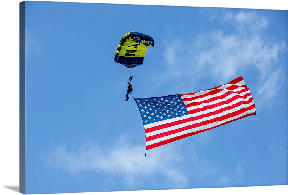 Member of the U.S. Navy Parachute Team flies the American Flag.