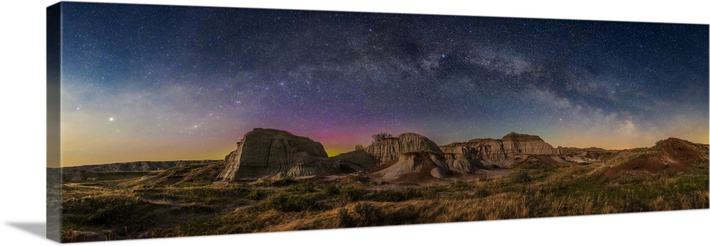 Panorama of the Milky Way arching over the badlands formations at Dinosaur Provincial Park, Alberta, Canada