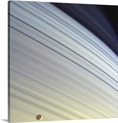 Mimas drifts along in its orbit against the azure backdrop of Saturns northern latitudes