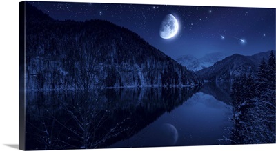Moon rising over tranquil lake in the misty mountains against starry sky