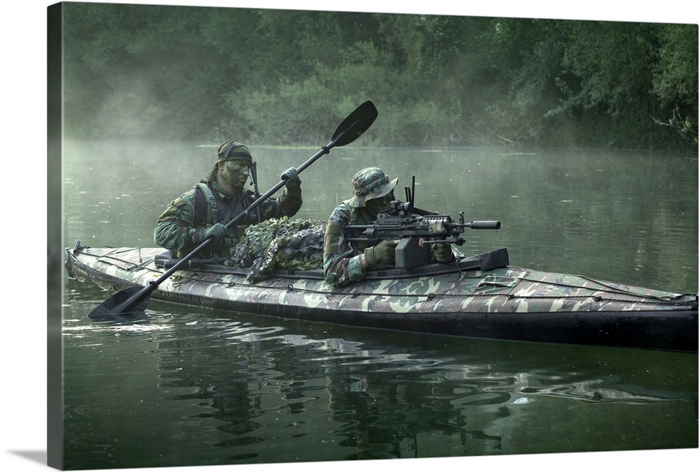 Navy SEALs navigate the waters in a folding kayak during jungle warfare operations.