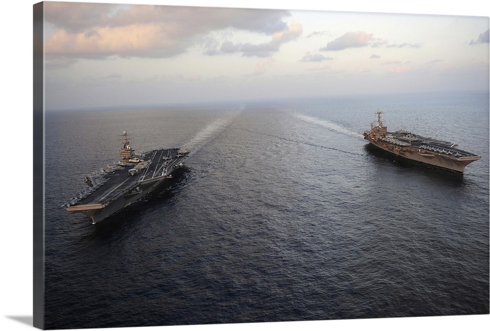 Nimitz-class aircraft carriers transit the Arabian Sea.