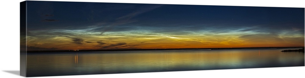 A panorama of noctilucent clouds in deep twilight over Crawling Valley Reservoir in Alberta, Canada