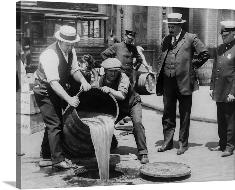 New York City Deputy Police Commissioner John A. Leach watching agents pour liquor into sewer during the height of prohibi...