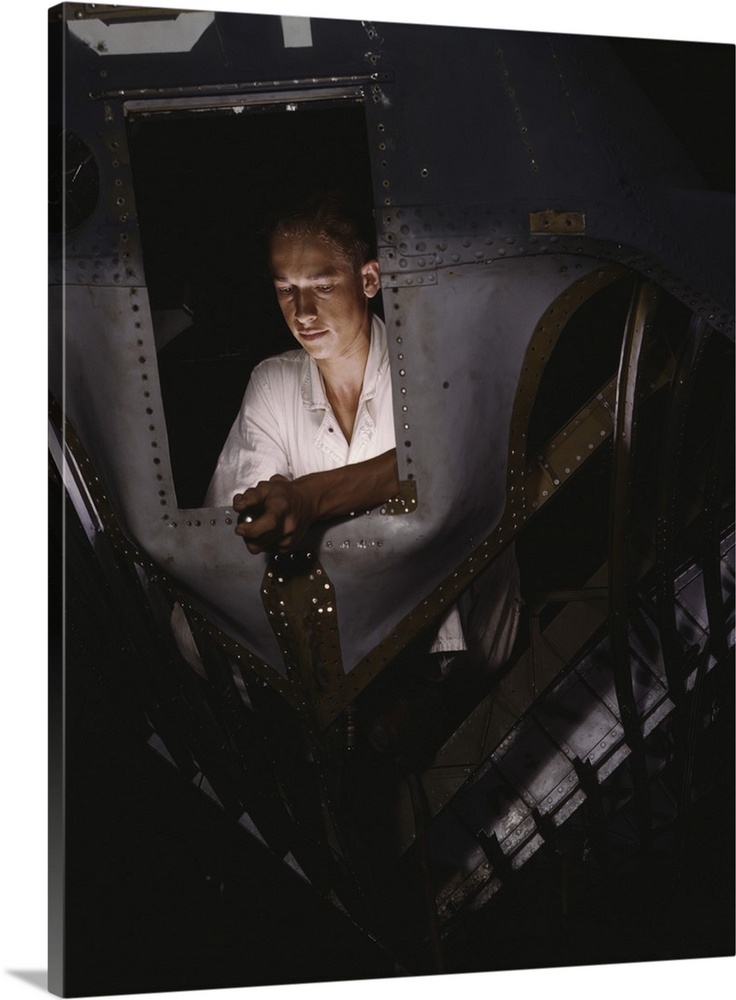 August 1942 - A National Youth Administration trainee working inside the nose cone of a PBY Catalina Navy plane, Corpus Ch...