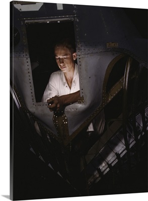 NYS trainee working inside the nose cone of a PBY Catalina Navy plane