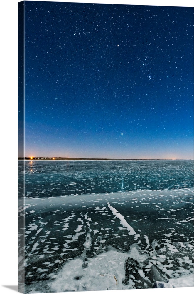 Orion and the Dog Stars rising over a frozen Lake MacGregor in southern Alberta, Canada.