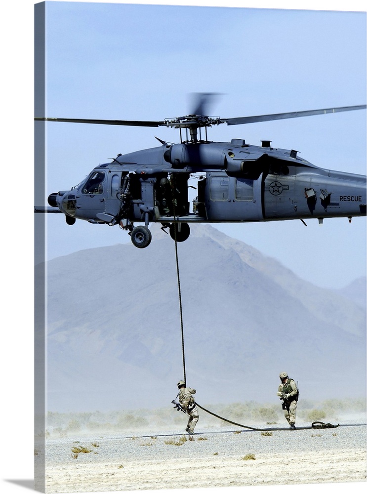 Pararescuemen descend from an HH-60 Pave Hawk helicopter.