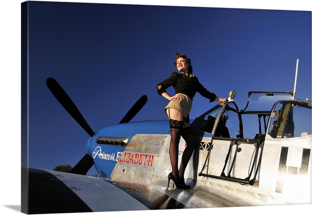 Pin-up girl standing on the wing of a P-51 Mustang fighter plane.