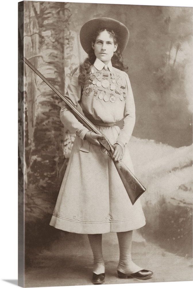 Portrait of sharpshooter Annie Oakley holding a rifle.