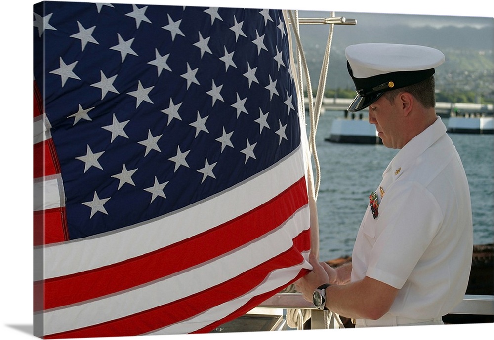 Sailor raises an American flag above the USS Arizona Memorial in Pearl Harbor, Hawaii.