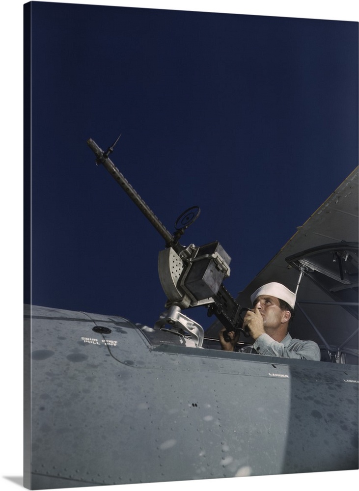 August 1942 - Sailor tries out a .30-caliber machine gun on a Navy plane at Naval Air Base, Corpus Christi, Texas.