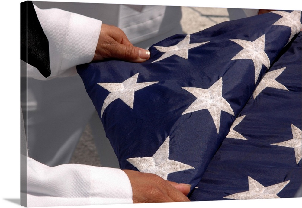 Sailors assigned to the colors detail fold the national ensign.