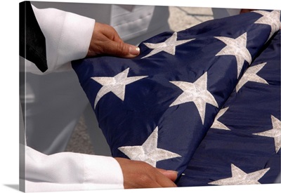 Sailors assigned to the colors detail fold the national ensign