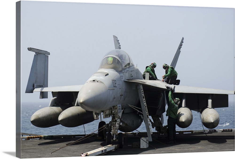 Gulf of Oman, August 22, 2013 - Sailors perform maintenance on an F/A-18F Super Hornet aboard the flight deck of the aircr...