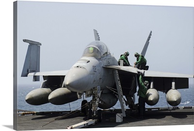 Sailors perform maintenance on an F/A-18F Super Hornet