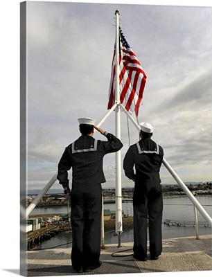 Sailors raise the national ensign aboard USS Abraham Lincoln