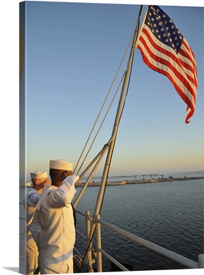 Sailors salute the national ensign aboard USS Bataan