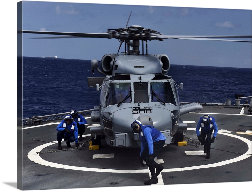Sailors secure an MH-60R Seahawk helicopter to the flight deck of USS Porter.