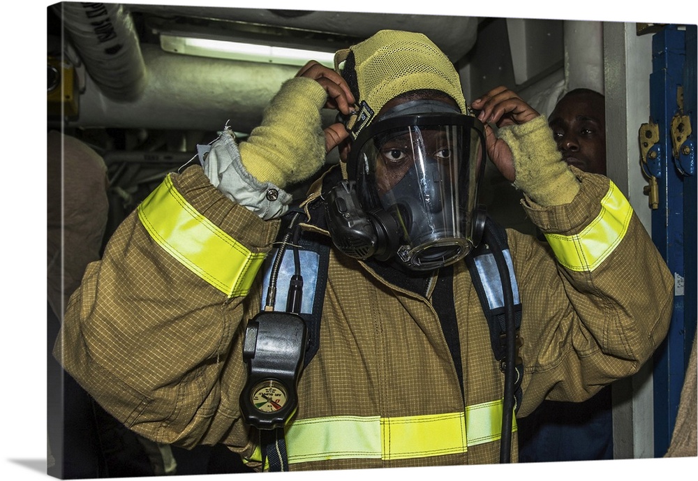 East China Sea, February 6, 2015 - Seaman dons his firefighting ensemble during a general quarters drill aboard the amphib...