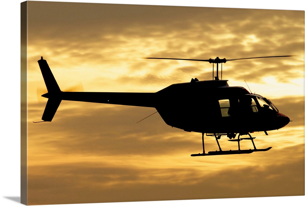 Silhouette of a Bell 206 utility helicopter of Italy's Vigili del Fuoco flying over Italy.