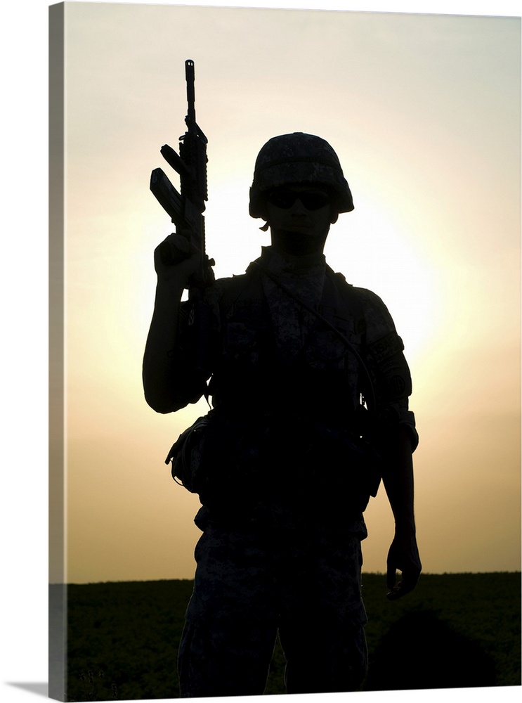 Silhouette of U.S. soldier with rifle against a sunset.