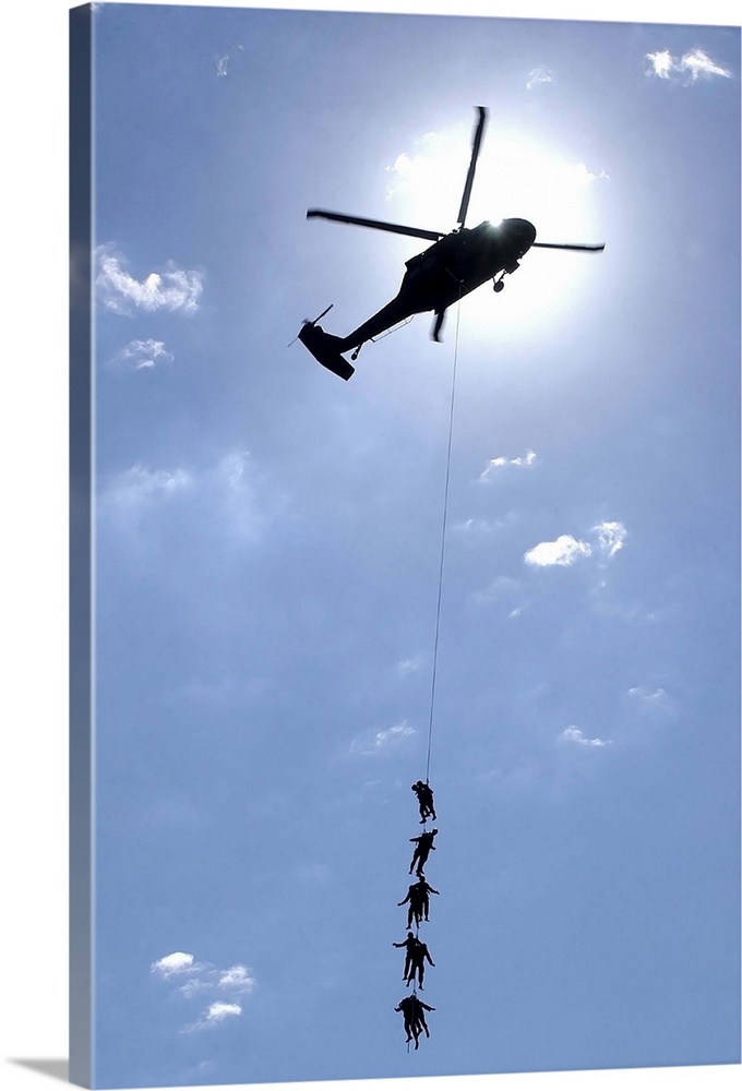 Soldiers and Airmen hang 100 feet above the ground from a UH-60 Blackhawk.