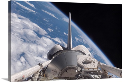 Space Shuttle Discovery backdropped by Earth
