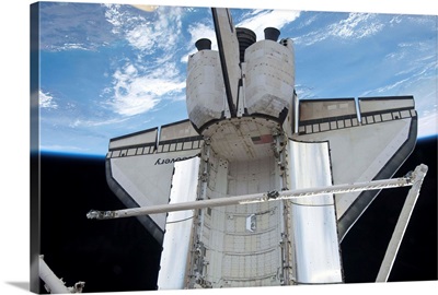 Space shuttle Discovery backdropped by Earth's horizon