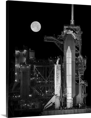 Space Shuttle Discovery Sits Atop The Launch Pad With A Full Moon In Background