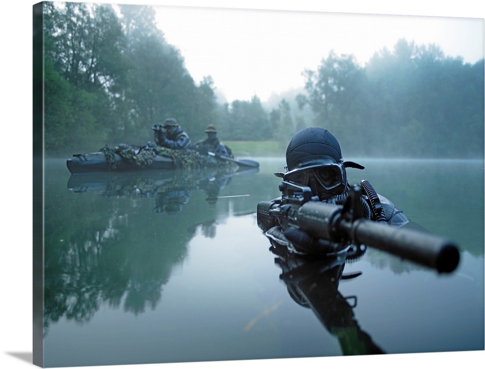 Landscape photograph of a special operations forces combat diver just above foggy water,  armed with an assault rifle.  A ...
