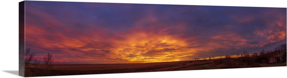 October 25, 2019 - Spectacular sunrise clouds in a panorama looking east and south over the fields from Alberta, Canada. -