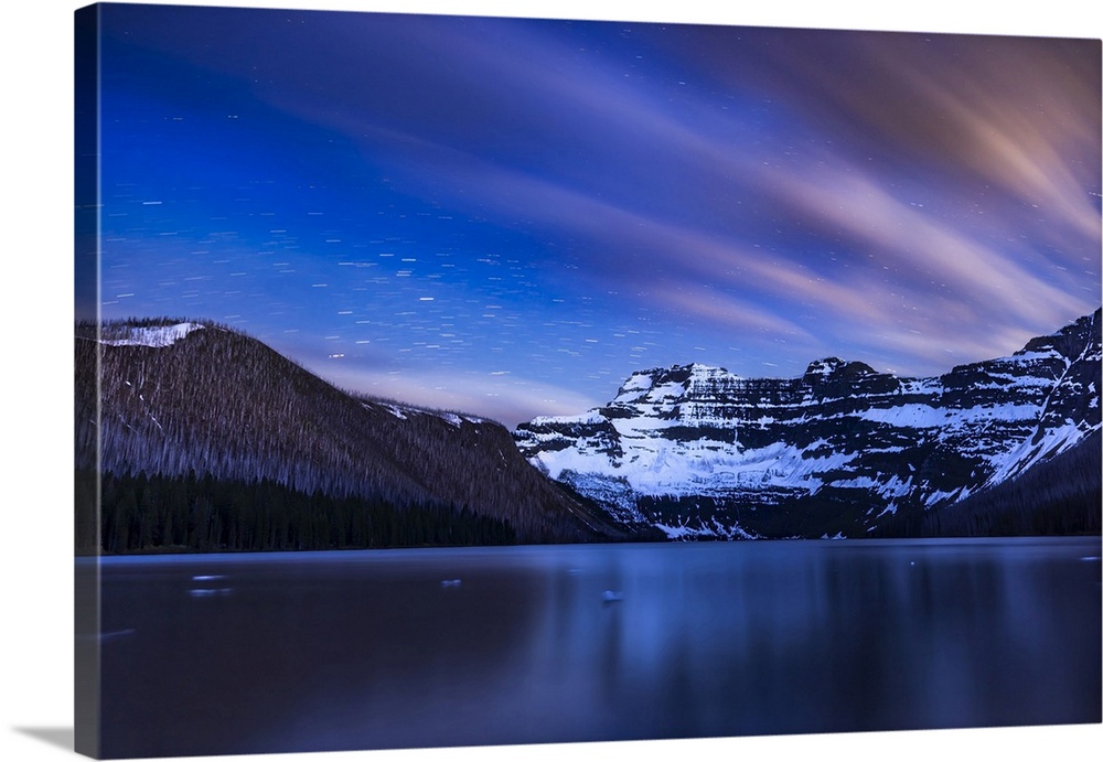 Star and cloud trails across the sky over Cameron Lake in Waterton Lakes National Park, Alberta, Canada