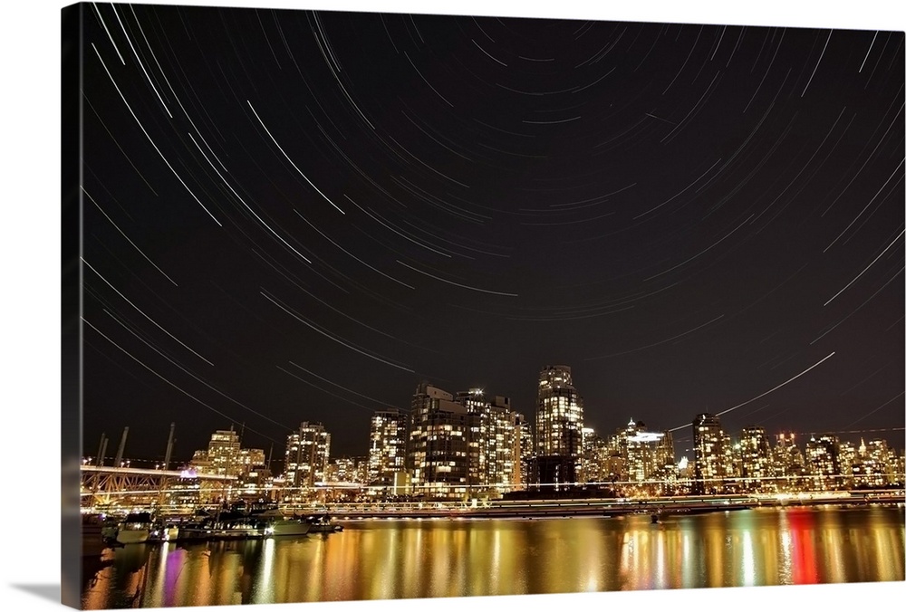 Landscape, big photograph of the Vancouver skyline at night, under a large sky with circular patters of star trails, in Br...