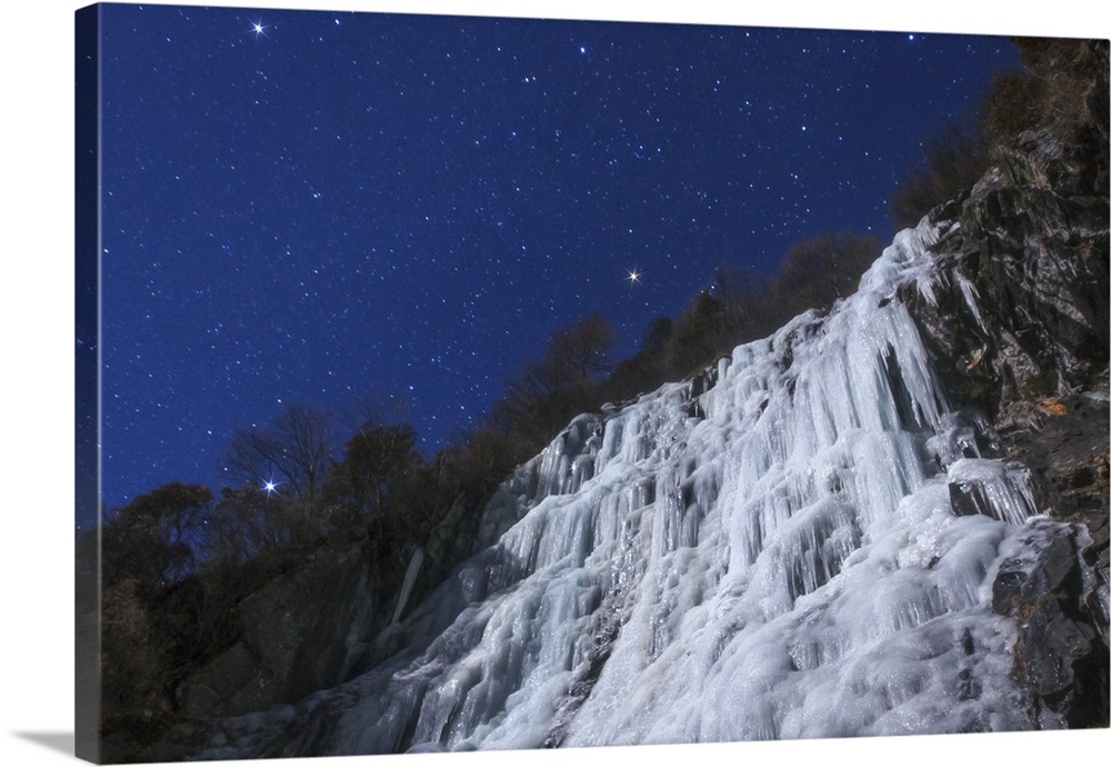 Stars of the Winter Triangle shine above an icefall on a moonlit night in the Sichuan province of China.
