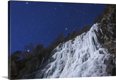 Stars shine above an icefall on a moonlit night in China