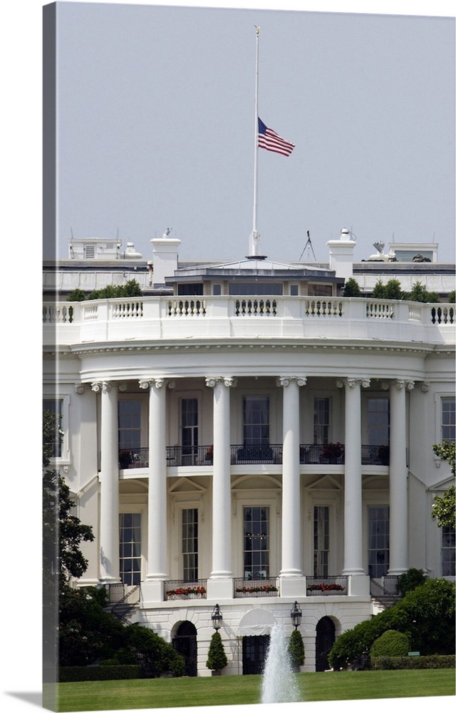 The American flag flies at half-staff atop the White House.