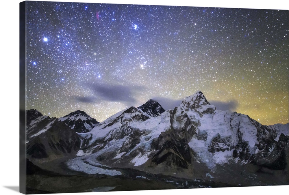 The bright stars of constellation Auriga and Taurus rise above the central Himalayas. Mount Everest (8848m) stand with ban...