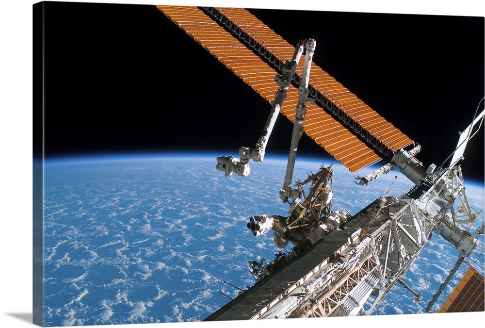 The Canadarm2 and solar array panel wings on the International Space ...