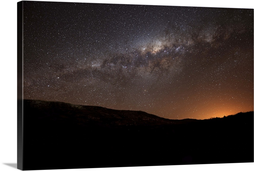 The Milky Way setting behind the hills of Azul, Argentina, part of the Tandilia Hills. The light dome of the city of azul ...