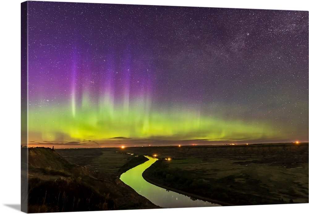 The northern lights dance over the Red Deer River and Badlands of Alberta, Canada.