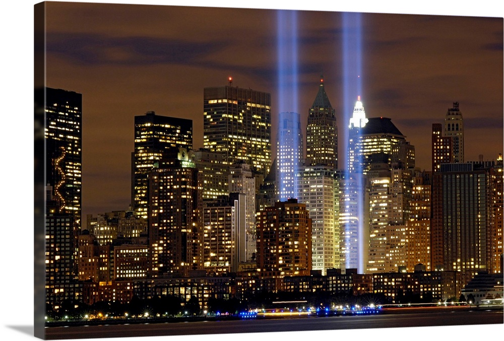 Two memorial rectangular lights shoot up into the night sky in NY symbolizing the two World Trade Center towers.