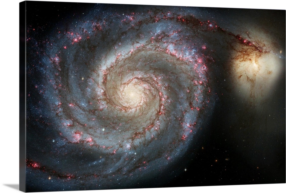 Photograph of swirling space galaxy M51 with another galaxy in the distance.