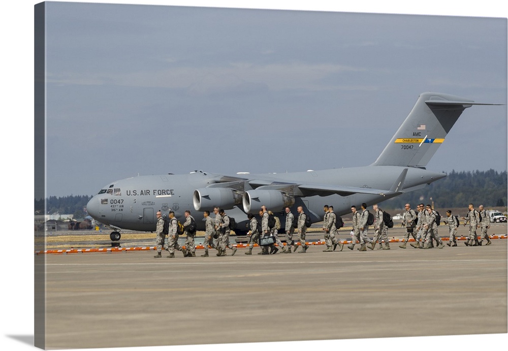 Troops unload from aboard a C-17 while another U.S. Air Force C-17 Globemaster III taxis in after landing at Portland Inte...