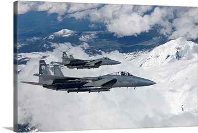 Two F-15 Eagles fly past snow-capped peaks in Central Oregon